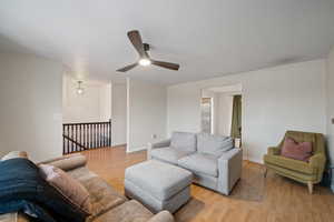 Living room featuring ceiling fan and light wood-type flooring