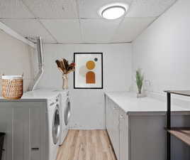 Laundry room featuring cabinets, light hardwood / wood-style floors, and independent washer and dryer