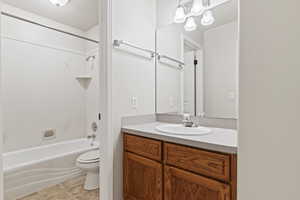 Full bathroom with vanity, tub / shower combination, tile patterned floors, and toilet