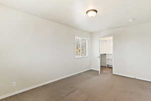 Unfurnished bedroom with a closet, carpet flooring, and a spacious closet