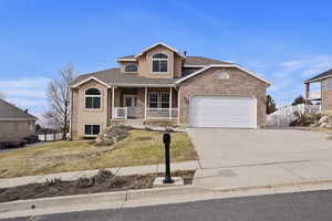 View of front property with a garage, a front yard, and covered porch