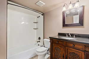 Full bathroom with toilet, tub / shower combination, a textured ceiling, vanity, and tile patterned flooring