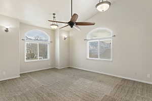 Spare room with ceiling fan, lofted ceiling, and carpet flooring