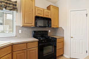 Kitchen featuring tasteful backsplash and black appliances