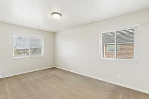 Unfurnished room featuring light carpet