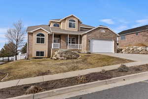 Front facade with a porch, a garage, and a front lawn