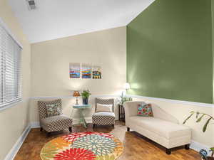 Sitting room with laminate wood look floors and vaulted ceiling