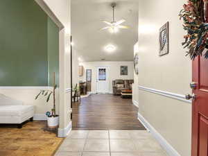 Tiled foyer and entry into great room area with laminate wood look flooring, vaulted ceilings and ceiling fan