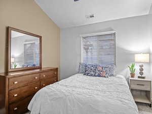 Bedroom featuring lofted ceiling and carpet