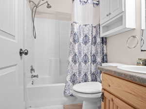 Full bathroom featuring vanity, shower / tub combo, and toilet