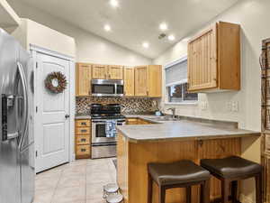 Kitchen featuring stainless steel appliances (all included), light tile flooring, walk in pantry and a breakfast bar,