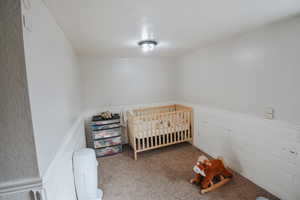 Carpeted bedroom with a crib