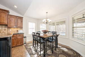 Dining area featuring an inviting chandelier and lofted ceiling