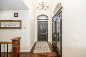 Foyer featuring an inviting chandelier and dark hardwood / wood-style floors