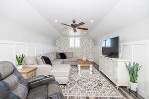 Living room featuring ceiling fan, vaulted ceiling, and hardwood / wood-style floors