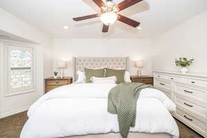 Carpeted bedroom featuring ceiling fan