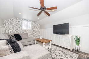 Living room with vaulted ceiling, wood-type flooring, and ceiling fan