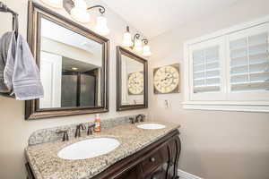 Bathroom featuring vanity and a shower with shower door