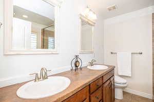 Bathroom with vanity, tile patterned floors, and toilet