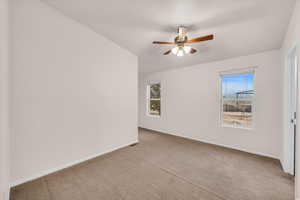 Empty room featuring light carpet and ceiling fan