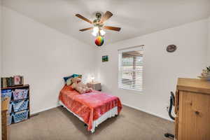 Carpeted bedroom featuring ceiling fan