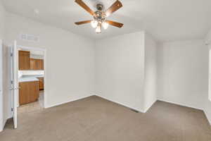 Carpeted spare room with ceiling fan