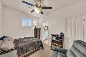 Bedroom featuring ensuite bath, light colored carpet, and ceiling fan