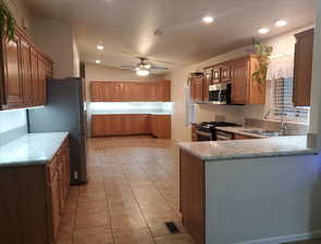 Kitchen with ceiling fan, stainless steel appliances, kitchen peninsula, and sink