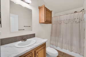 Full bathroom featuring vanity, shower / tub combo, tile patterned flooring, and toilet