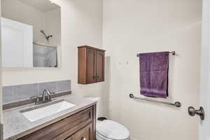 Bathroom with vanity, toilet, and an enclosed shower