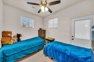 Bedroom featuring multiple windows, carpet floors, and ceiling fan