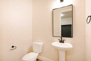 Half bath featuring baseboards and toilet
