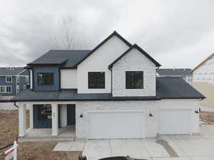 View of front of house featuring roof with shingles, covered porch, concrete driveway, a garage, and board and batten siding