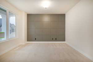 Empty room featuring baseboards, light carpet, and visible vents