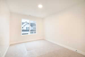 Carpeted spare room with baseboards and visible vents