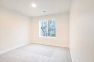 Empty room featuring recessed lighting, baseboards, visible vents, and light carpet