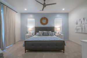 Bedroom featuring multiple windows, light carpet, and ceiling fan