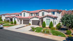 Mediterranean / spanish-style home featuring a garage and a front yard