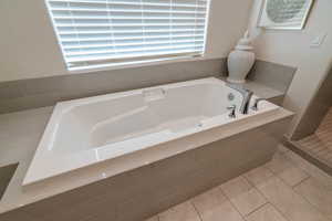 Bathroom featuring tile patterned floors and tiled bath