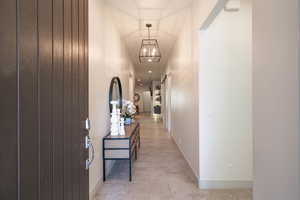 Hallway featuring a barn door and a chandelier