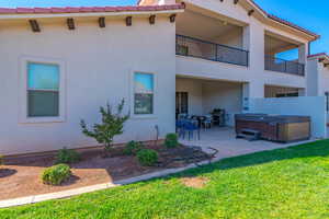 Rear view of house featuring a hot tub and a patio