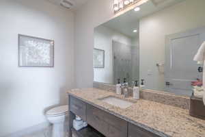 Bathroom with vanity, tile patterned floors, toilet, and walk in shower