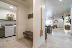 Laundry area with light tile patterned flooring and separate washer and dryer