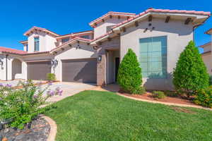 Mediterranean / spanish-style house featuring a garage and a front yard