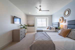 Bedroom featuring light colored carpet, a textured ceiling, and ceiling fan