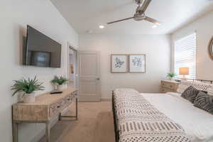 Carpeted bedroom featuring ceiling fan