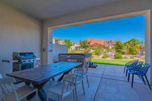 View of patio with a hot tub, a mountain view, and a grill