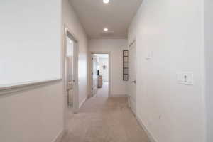 Corridor with light colored carpet