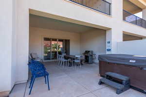 View of patio featuring area for grilling and a hot tub