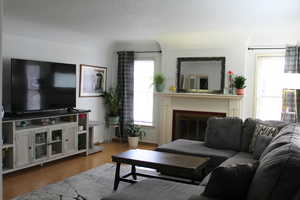 Spacious living room with lots of light, featuring a wood burning fireplace